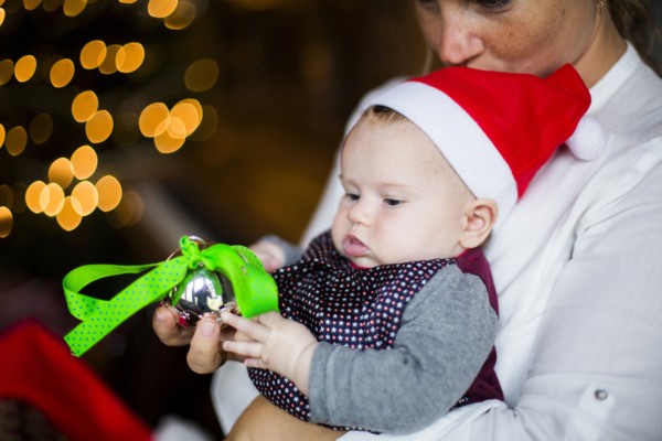 Close up of mother holding baby girl with Christmas ornament