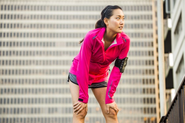 Runner resting near highrise building