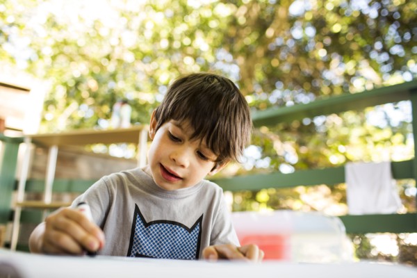 Mixed race boy coloring on porch