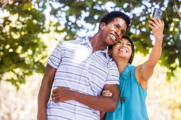 Couple taking selfie with cell phone outdoors