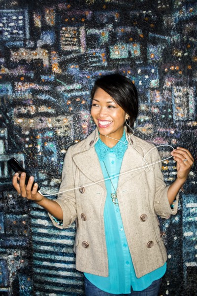 Woman listening to cell phone by mural