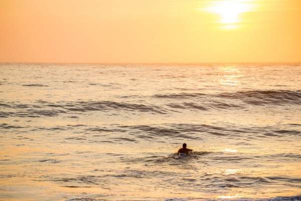 Caucasian surfer swimming in waves