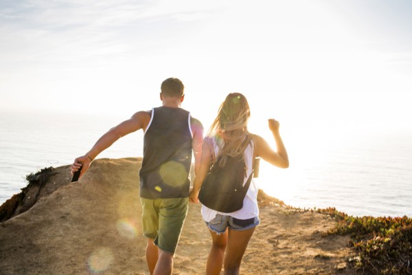 Caucasian couple walking on cliff