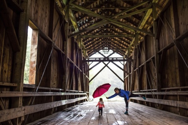Caucasian mother and baby daughter on covered bridge