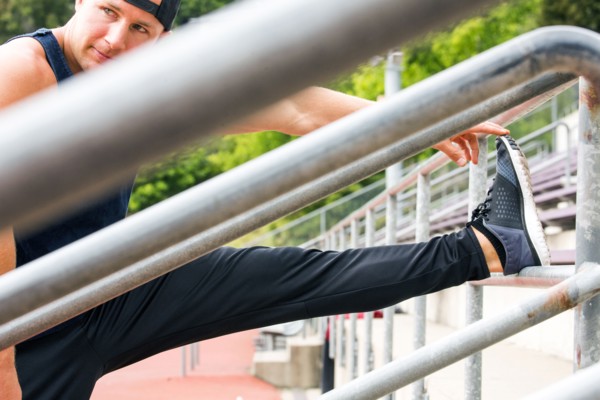 Caucasian man stretching leg at running track