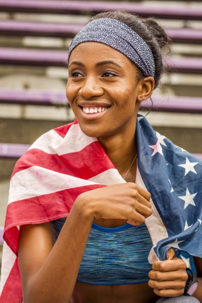 Smiling black athlete wrapped in American flag