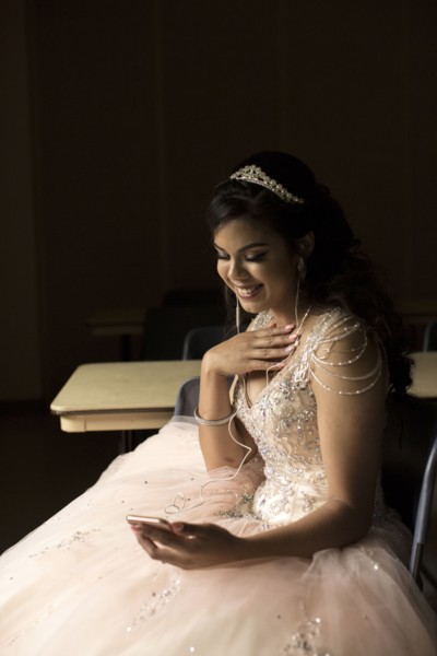 Smiling Hispanic girl listening to cell phone with earbuds