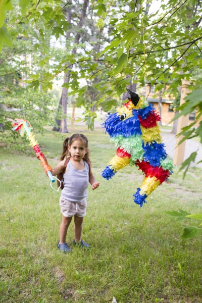 Mixed race girl hitting pinata outdoors