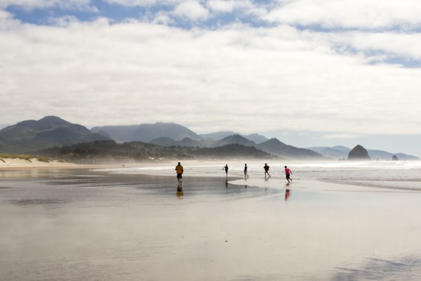 Distant people running on beach