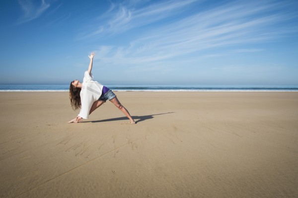 Caucasian woman practicing yoga on beach