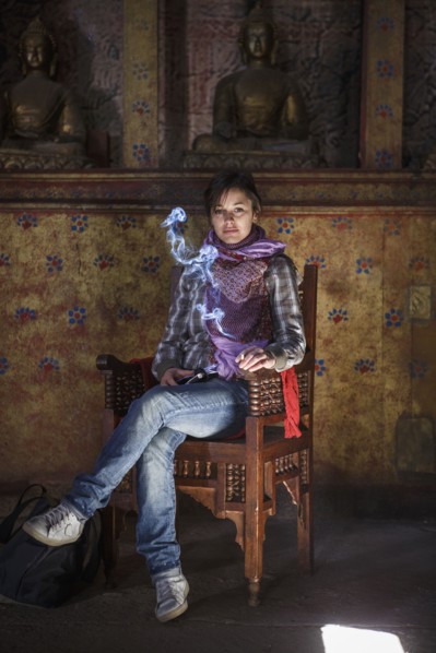Caucasian woman burning incense in ancient temple