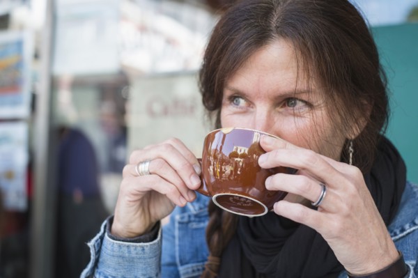 Caucasian woman drinking cup of coffee outdoors