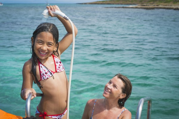 Mother and daughter playing on boat in water