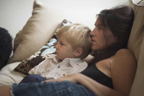 Caucasian mother and son watching television