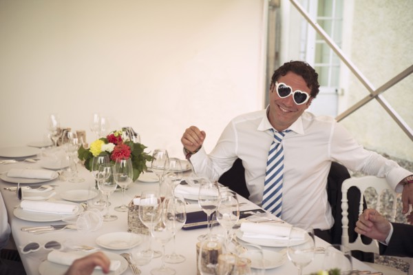 Caucasian man wearing heart-shaped glasses at table