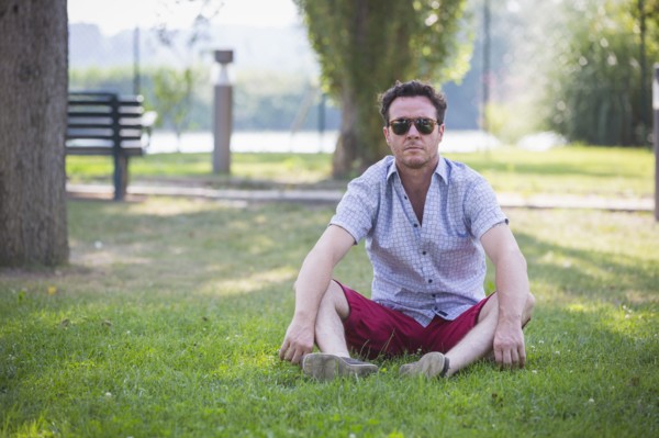 Caucasian man sitting in grass in park