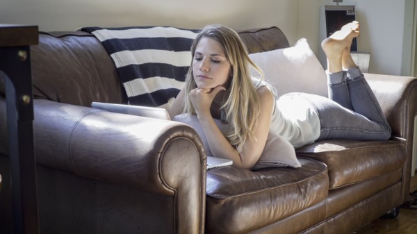 Caucasian woman using laptop on sofa