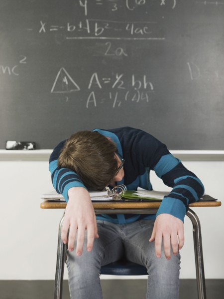 Student sleeping at desk in classroom