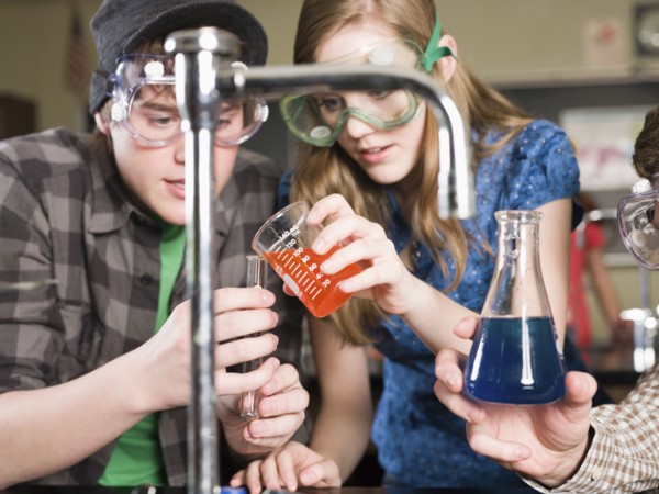 Students performing experiment in science lab classroom