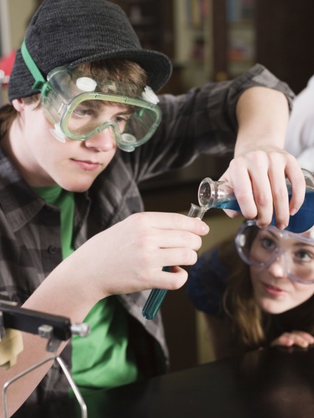 Students performing experiment in science lab classroom