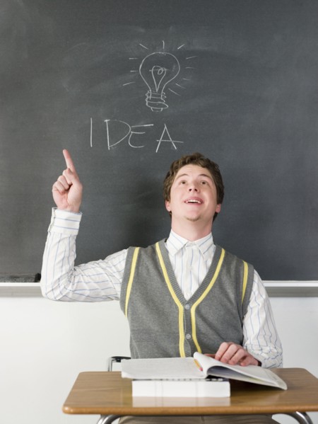 Student having idea under light bulb on chalkboard in classroom