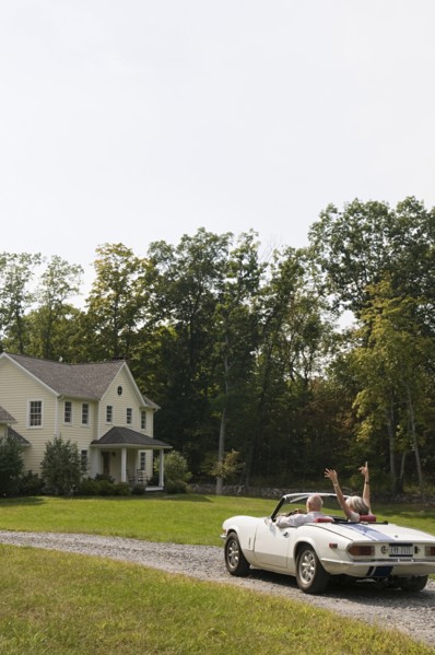 Rear view of older couple driving convertible