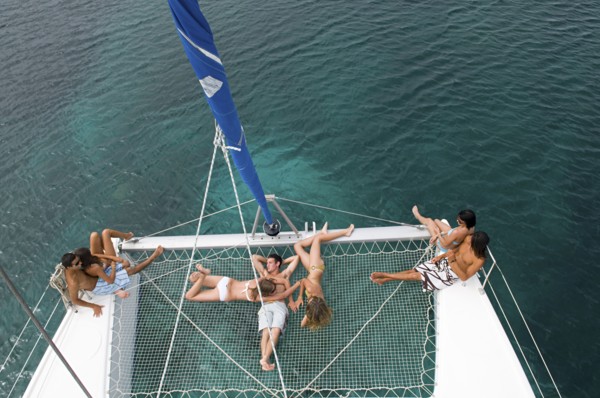 High angle view of friends sunbathing on sailboat
