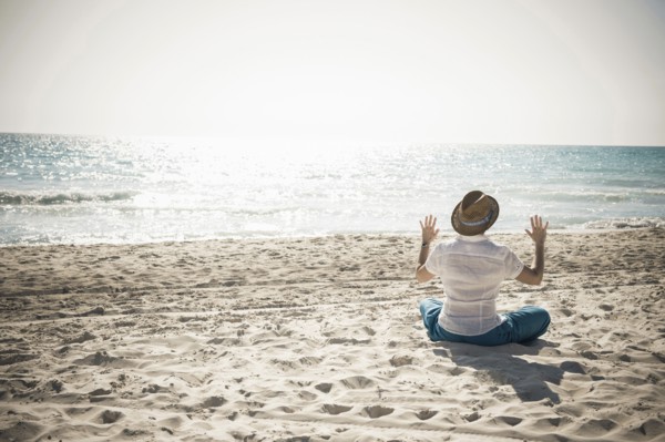 Caucasian man sitting on beach