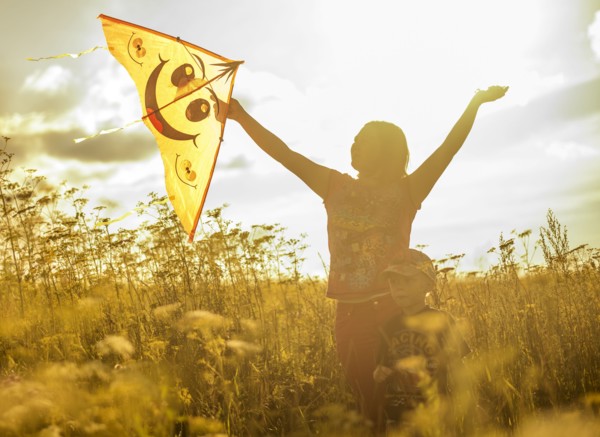 Caucasian mother and son flying kite in rural field