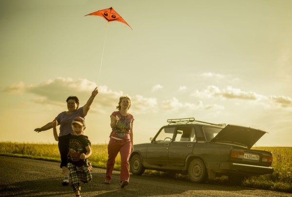 Caucasian family flying kite on rural road