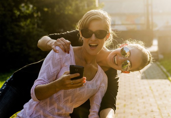 Caucasian women taking cell phone selfie