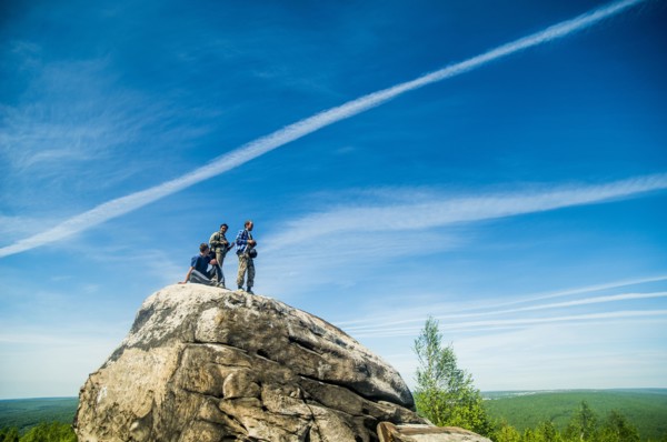 Caucasian climbers standing on rock formation