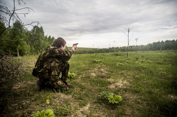 Caucasian man practicing shooting in rural field
