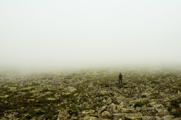 Caucasian hiker walking in rocky field