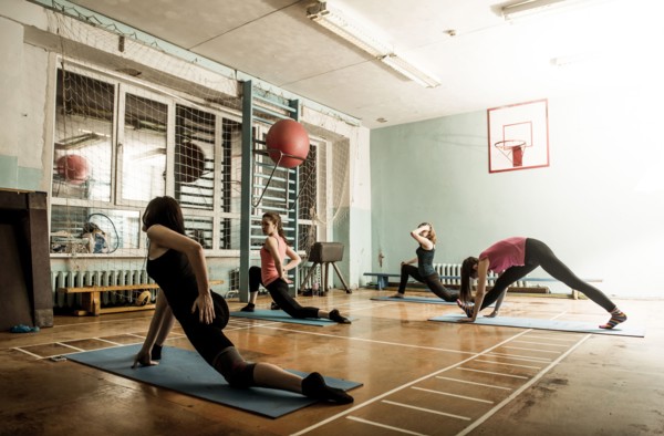 Caucasian dancers stretching in gym