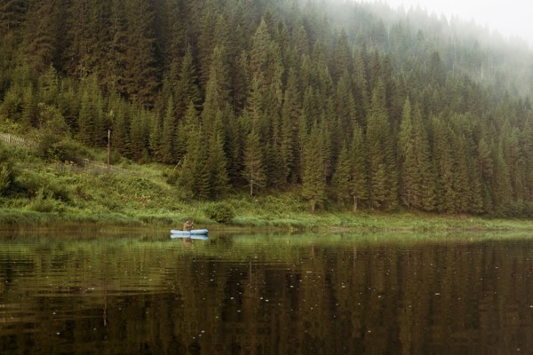 Caucasian man rowing canoe in remote lake