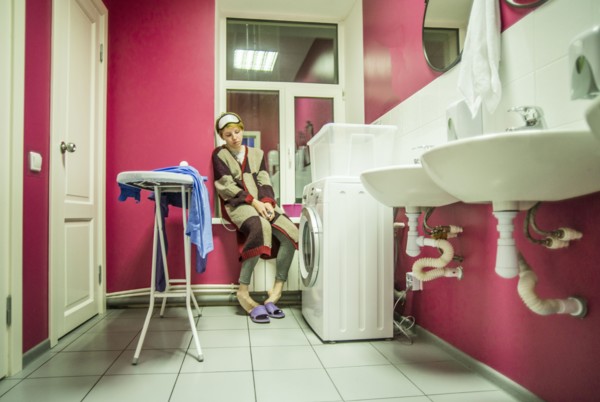 Caucasian woman waiting for laundry in bathroom