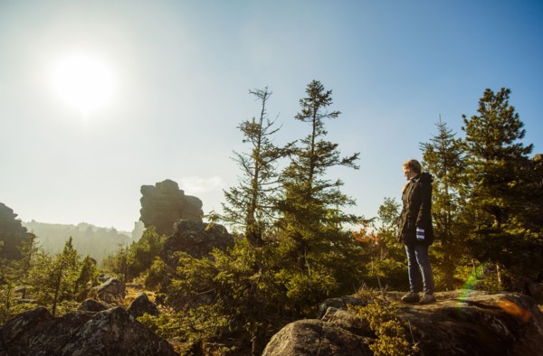Caucasian hiker admiring view from remote hilltop