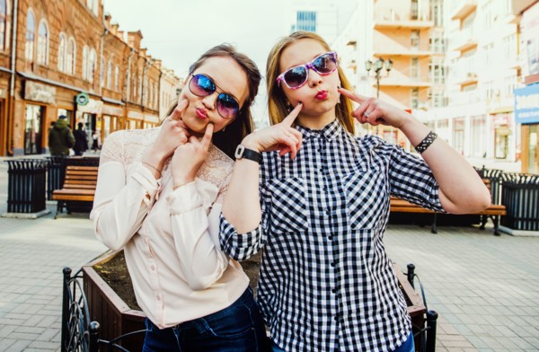 Women making faces in city