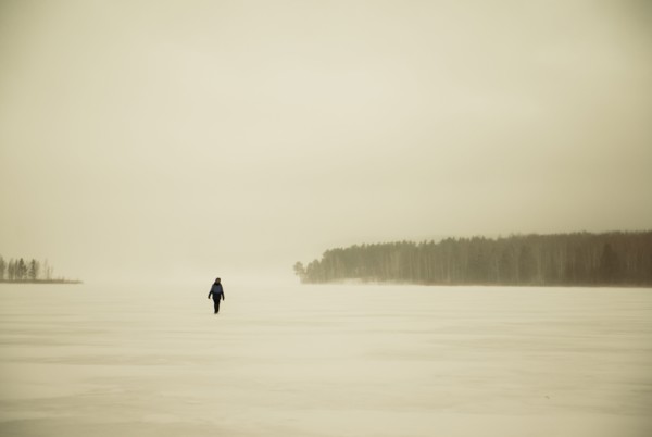 Caucasian hiker walking in snowy remote field
