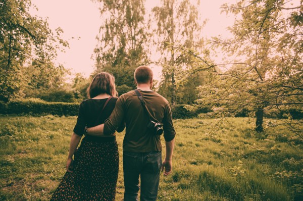 Caucasian couple walking in field