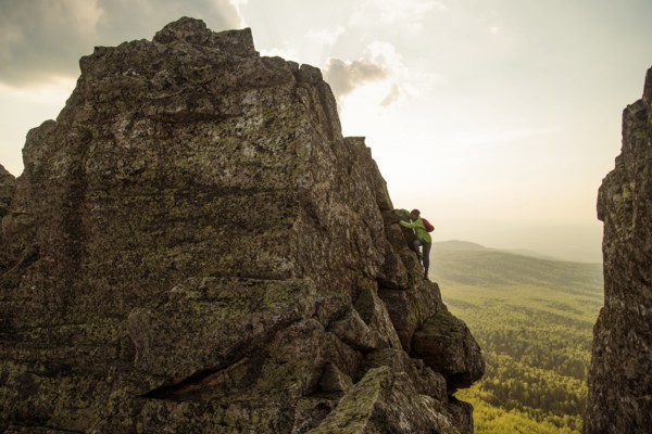 Caucasian hiker climbing on rock formation