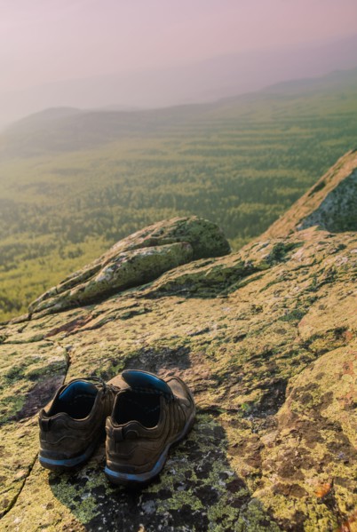 Close up of sneakers on rocky hilltop in remote landscape