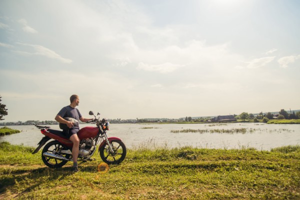 Caucasian man sitting on motorcycle in park