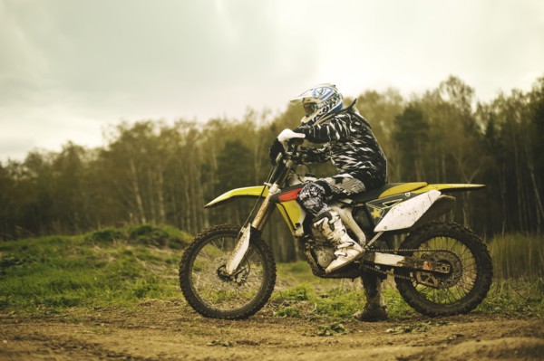 Caucasian man riding dirt bike in field