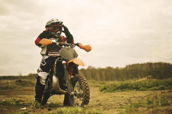 Caucasian man riding dirt bike in field