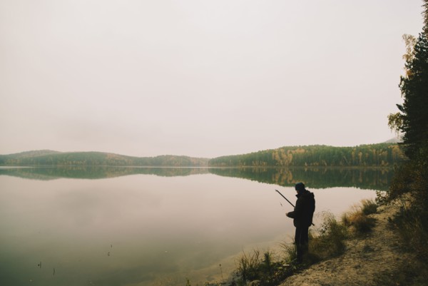 Man fishing in remote lake