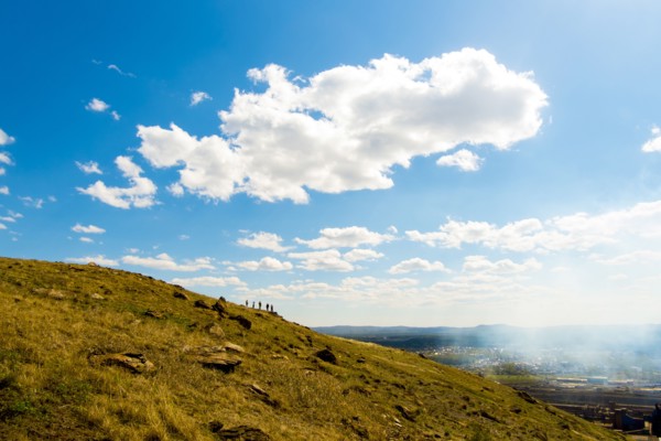 Clouds over Caucasian friends on distant hill