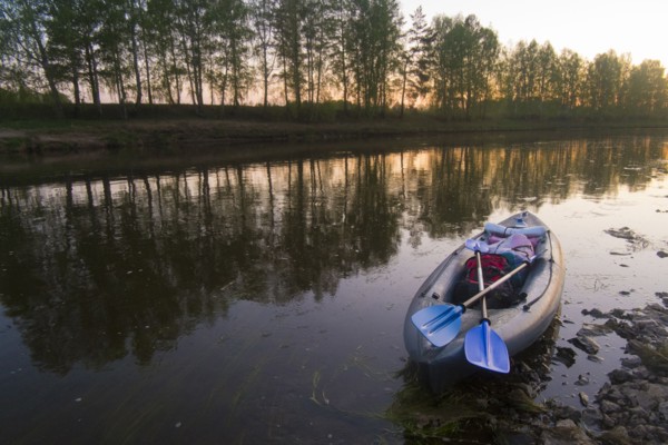 Oars on empty inflatable raft on river