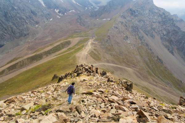 Caucasian man hiking on mountain rocks